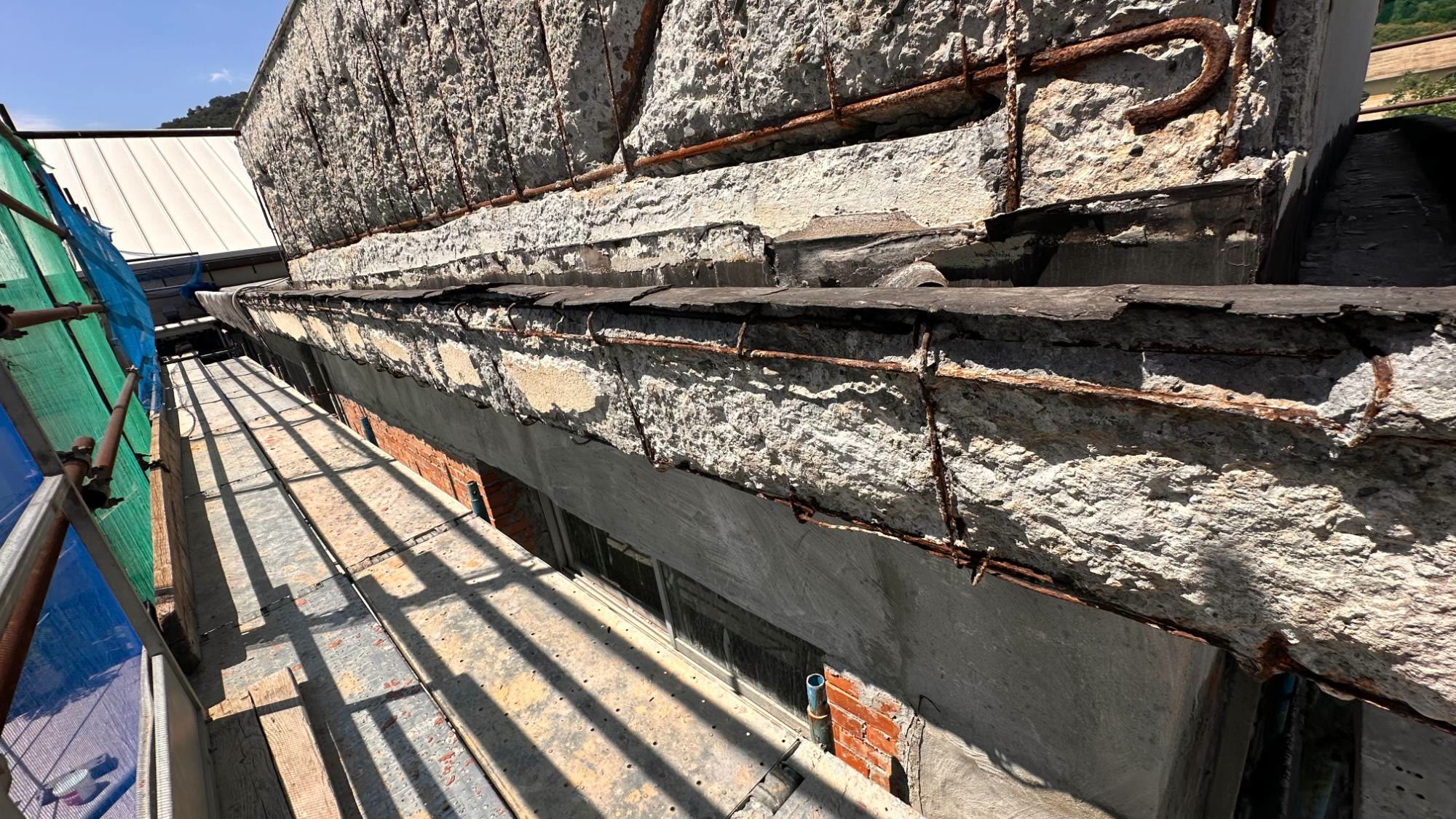 Le travi in cemento armato del vano scala scrostate fino ai ferri, viste dal ponteggio durante il consolidamento
