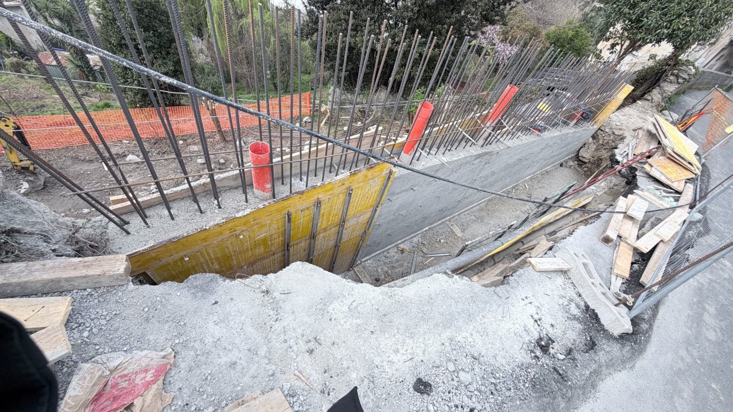 I ferri del parapetto e le casseforme del muro visti dall’alto, con i tubi di drenaggio arancioni