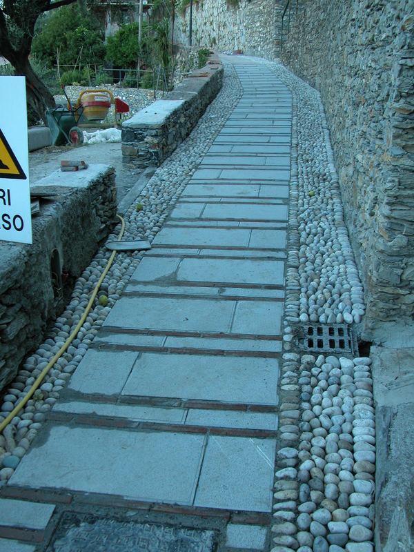 Scalinata pavimentata in lastre di arenaria bocciardata alternate a filari di mattoni, con canaletta in ciottoli
