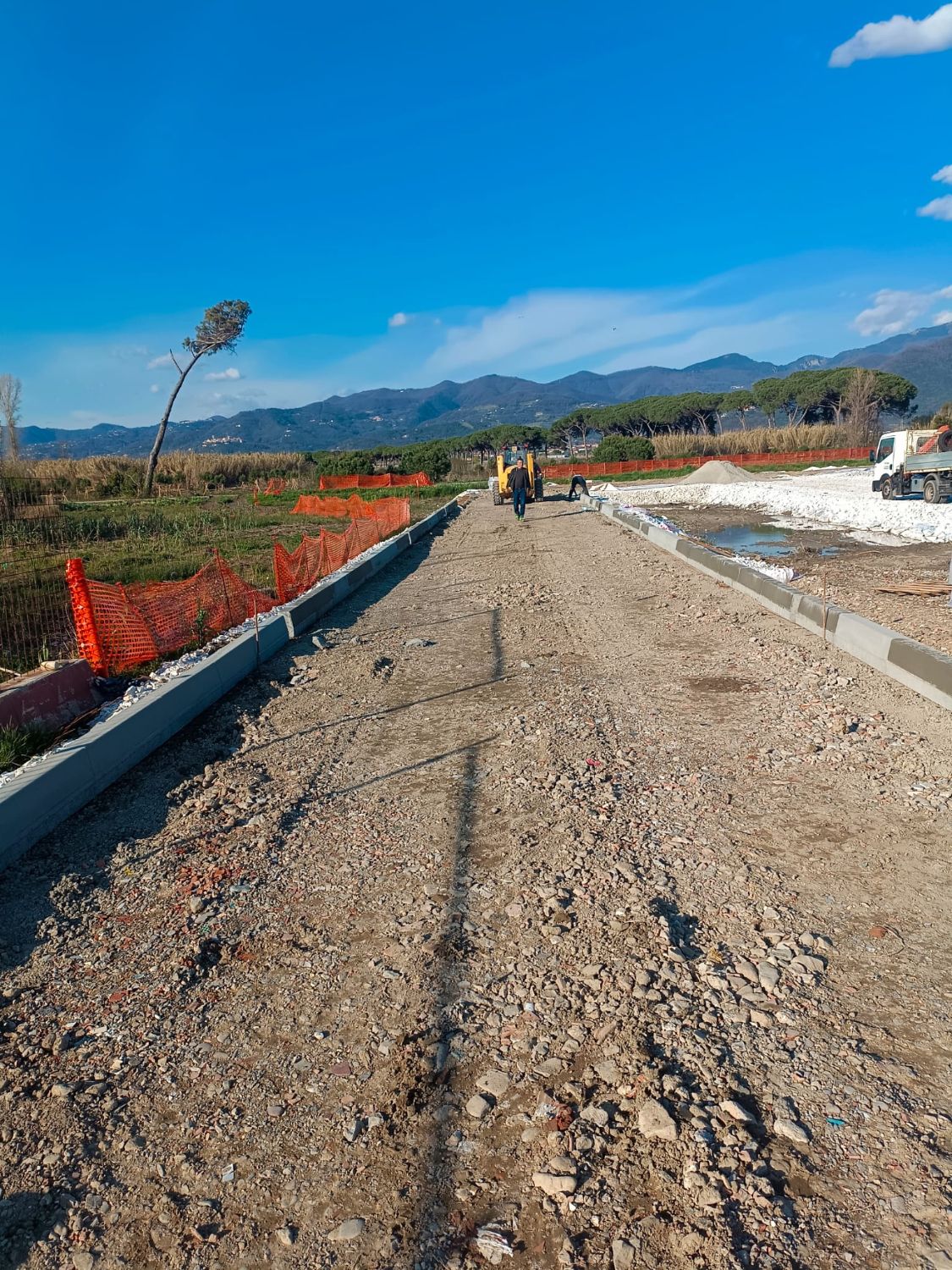 Nuova strada in costruzione con il sottofondo in misto e i cordoli in cemento appena posati ai due lati