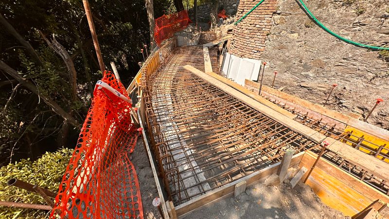 L’armatura in ferro di un tratto della salita dentro le casseforme in legno, con la rete arancione di cantiere