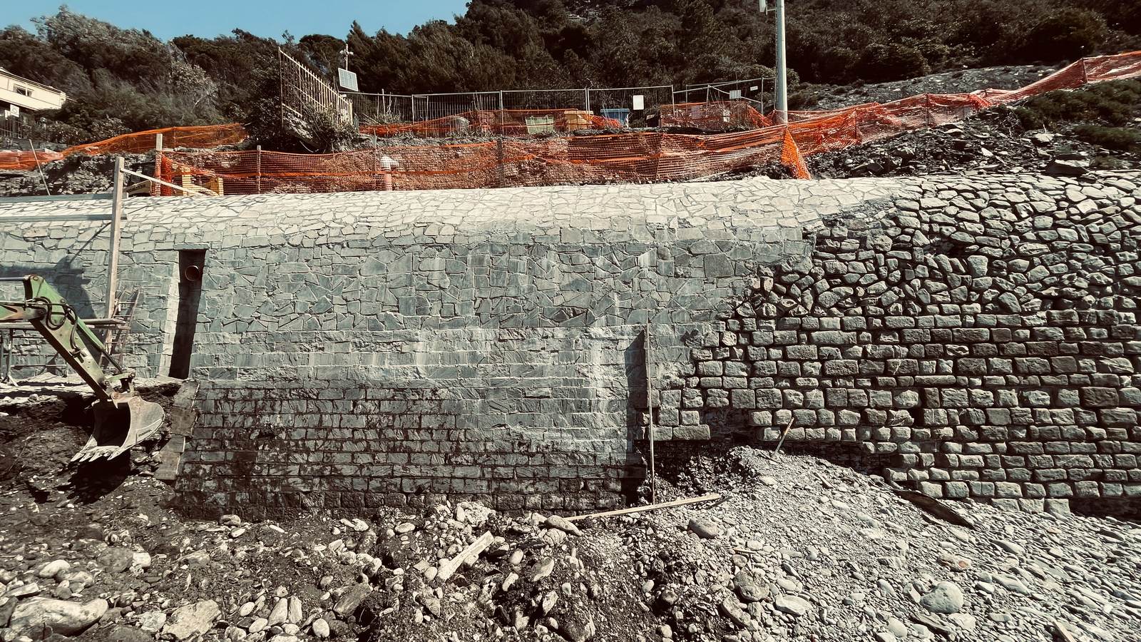 Il muro di sostegno rivestito in pietra a lavori ultimati, visto dalla spiaggia
