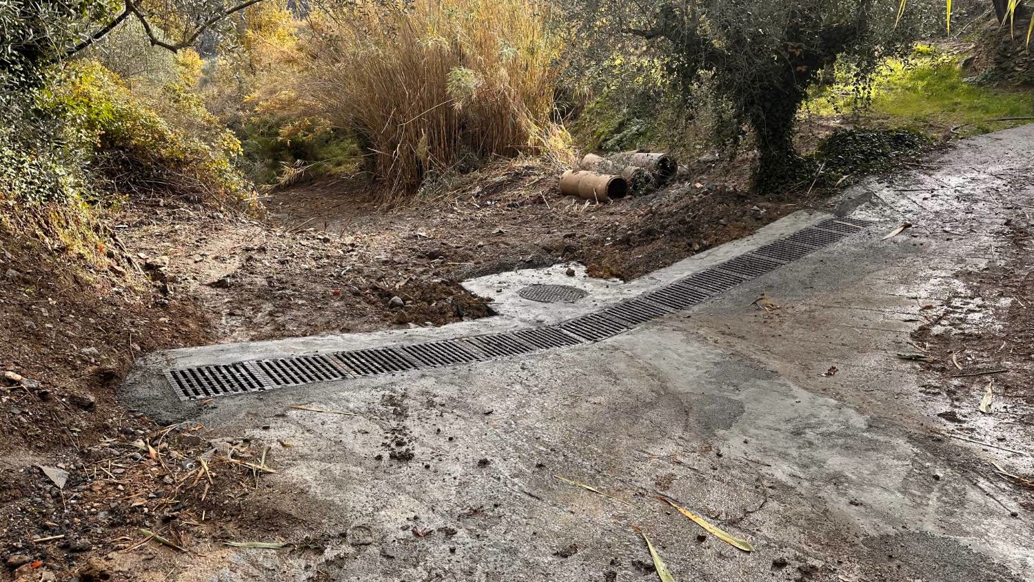 La nuova canaletta con la griglia in ghisa che attraversa la strada comunale di Crosa, con il pozzetto accanto